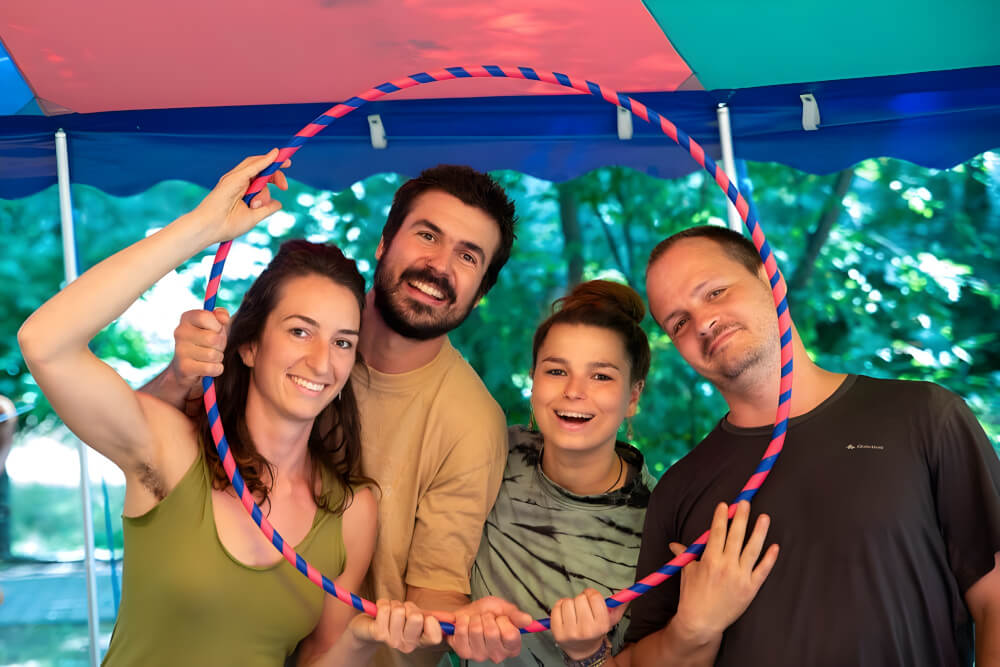 Vier Mitglieder des NICA-Teams halten gemeinsam einen großen Hula-Hoop-Reifen